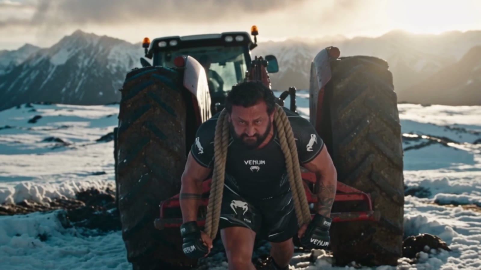Traction d'un tracteur à la corde, face aux montagnes