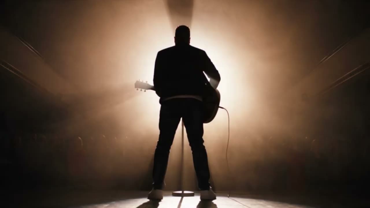 Silhouette guitare en main dans un contre-jour de scène