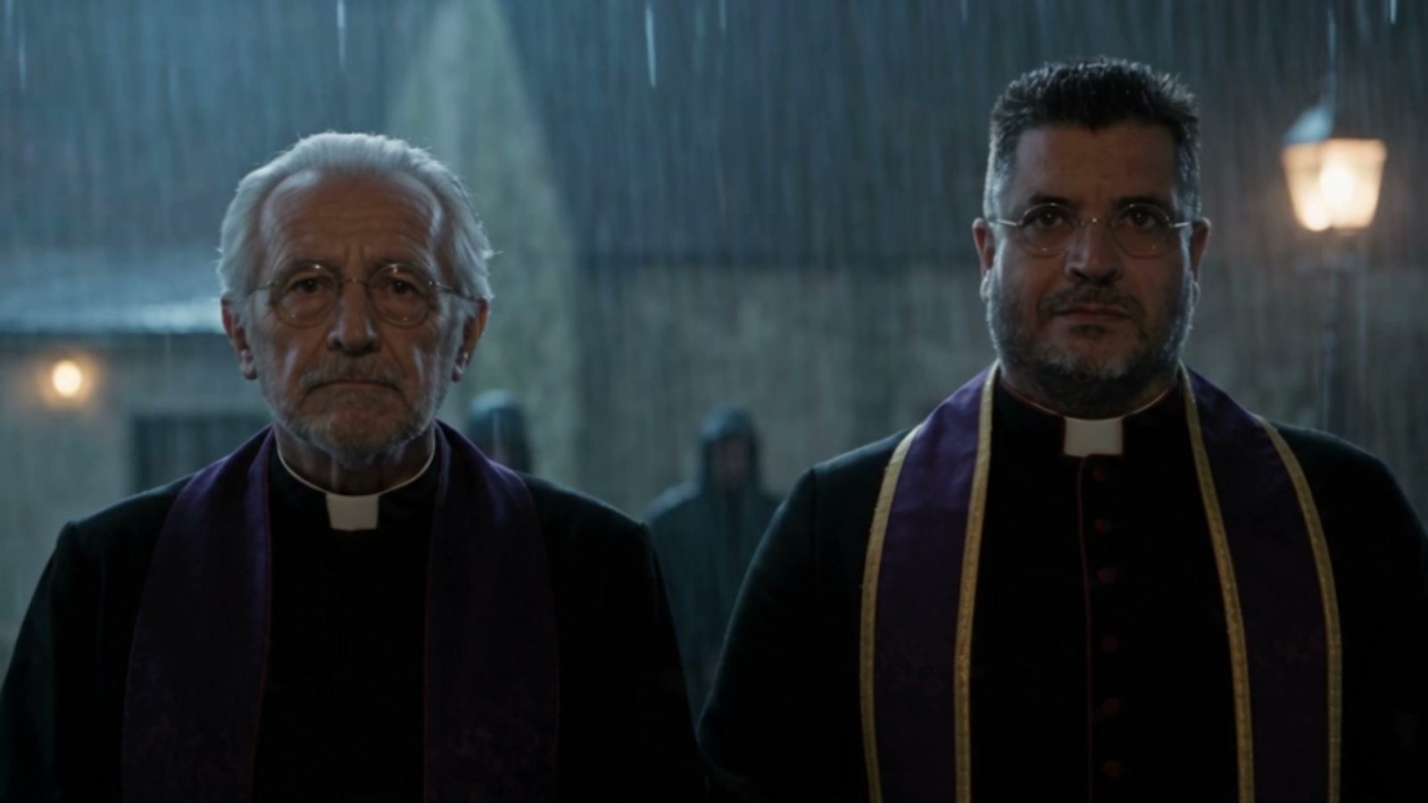 Les deux prêtres sous la pluie devant la maison, étole violette sur la soutane