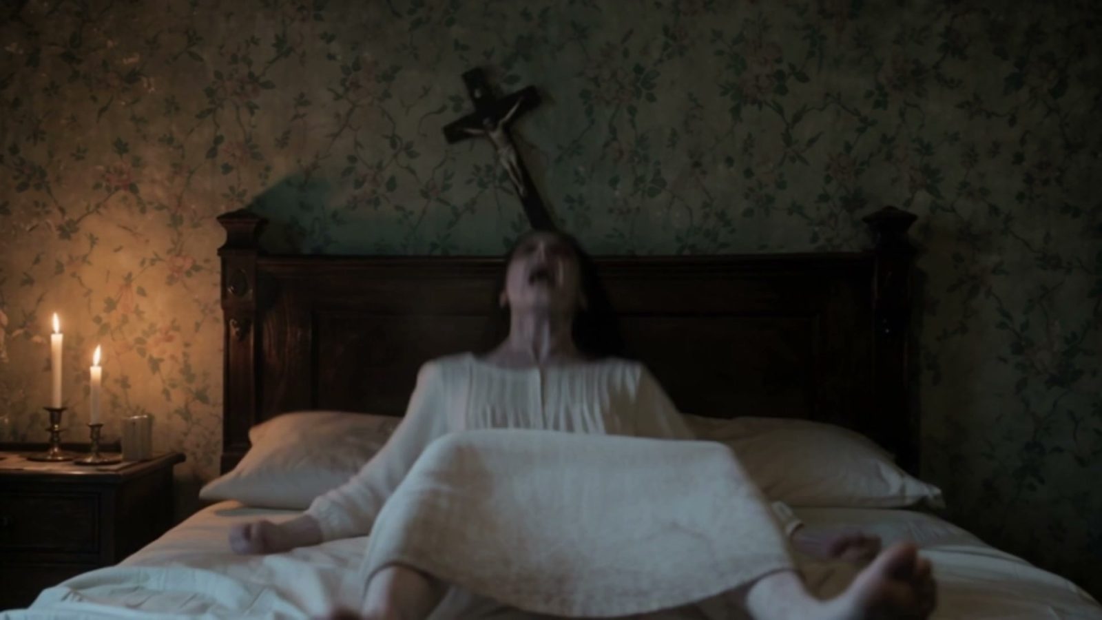 La possédée se redresse d'un coup, crucifix de travers au-dessus du lit