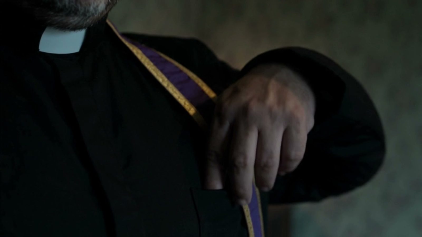 Détail de l'étole violette remise sur l'épaule avant de reprendre