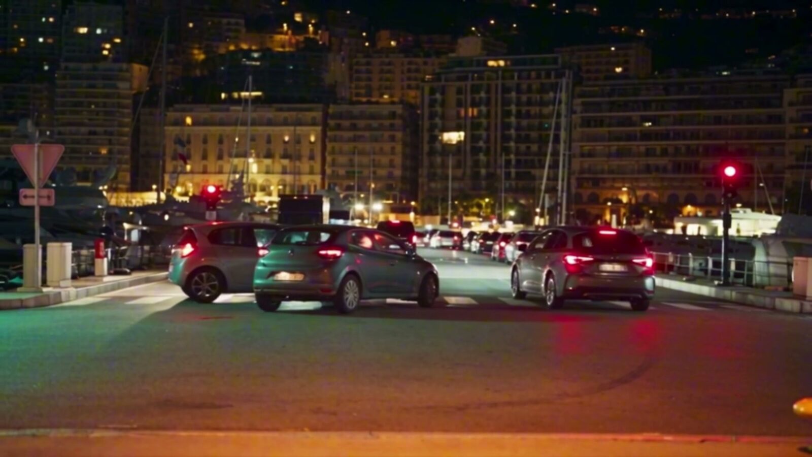 Le quai de Monaco la nuit, voitures à l'arrêt et immeubles éclairés au-dessus du port