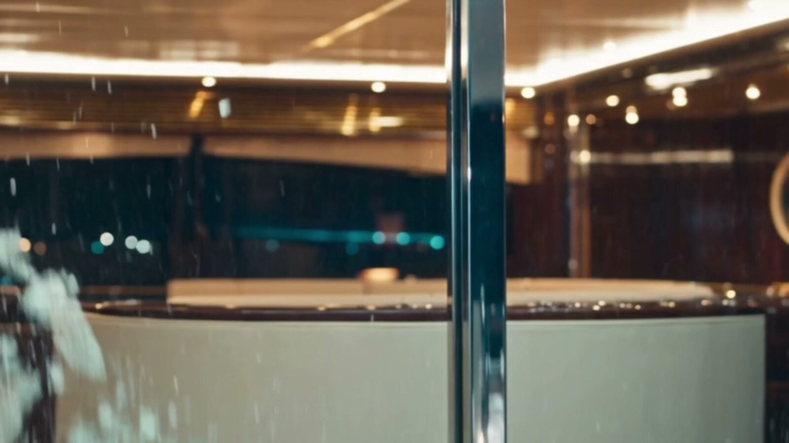 Le pont d'un yacht de luxe sous la pluie, jacuzzi éclairé et bastingage chromé