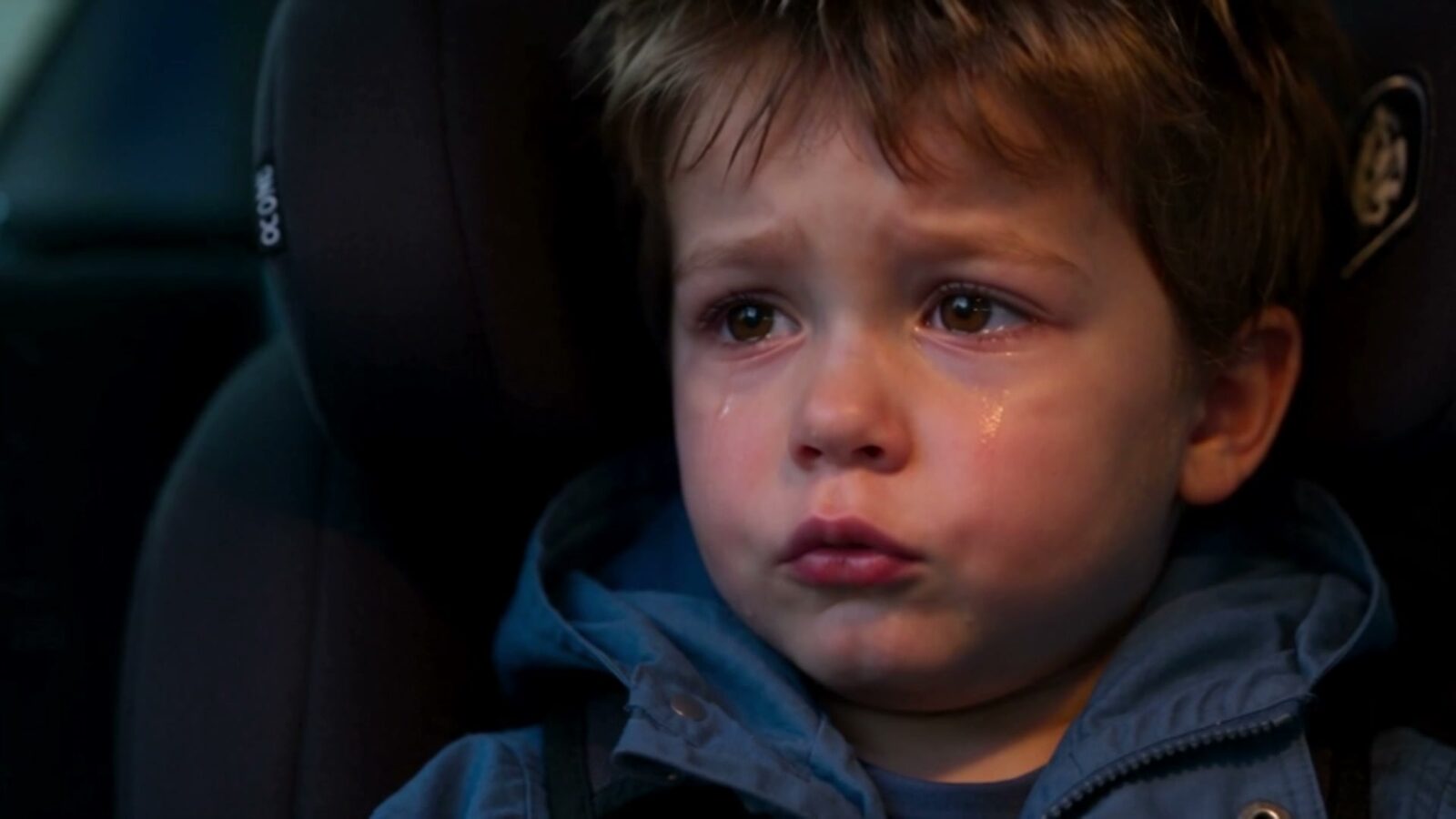Le petit garçon en larmes, attaché dans son siège auto
