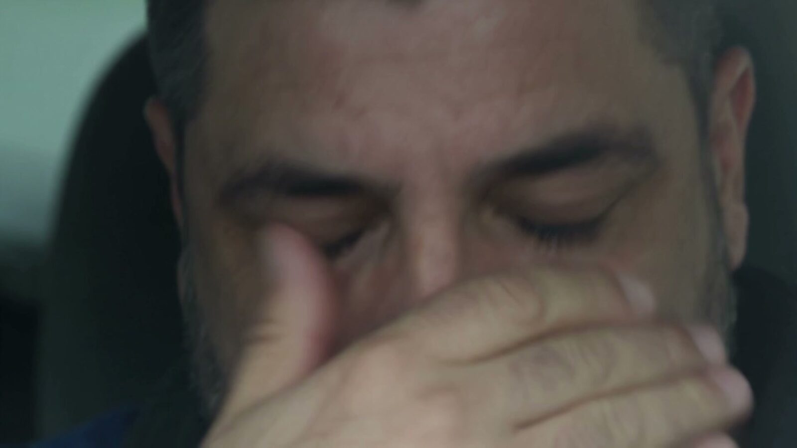 Le père dans sa voiture, la main sur le visage