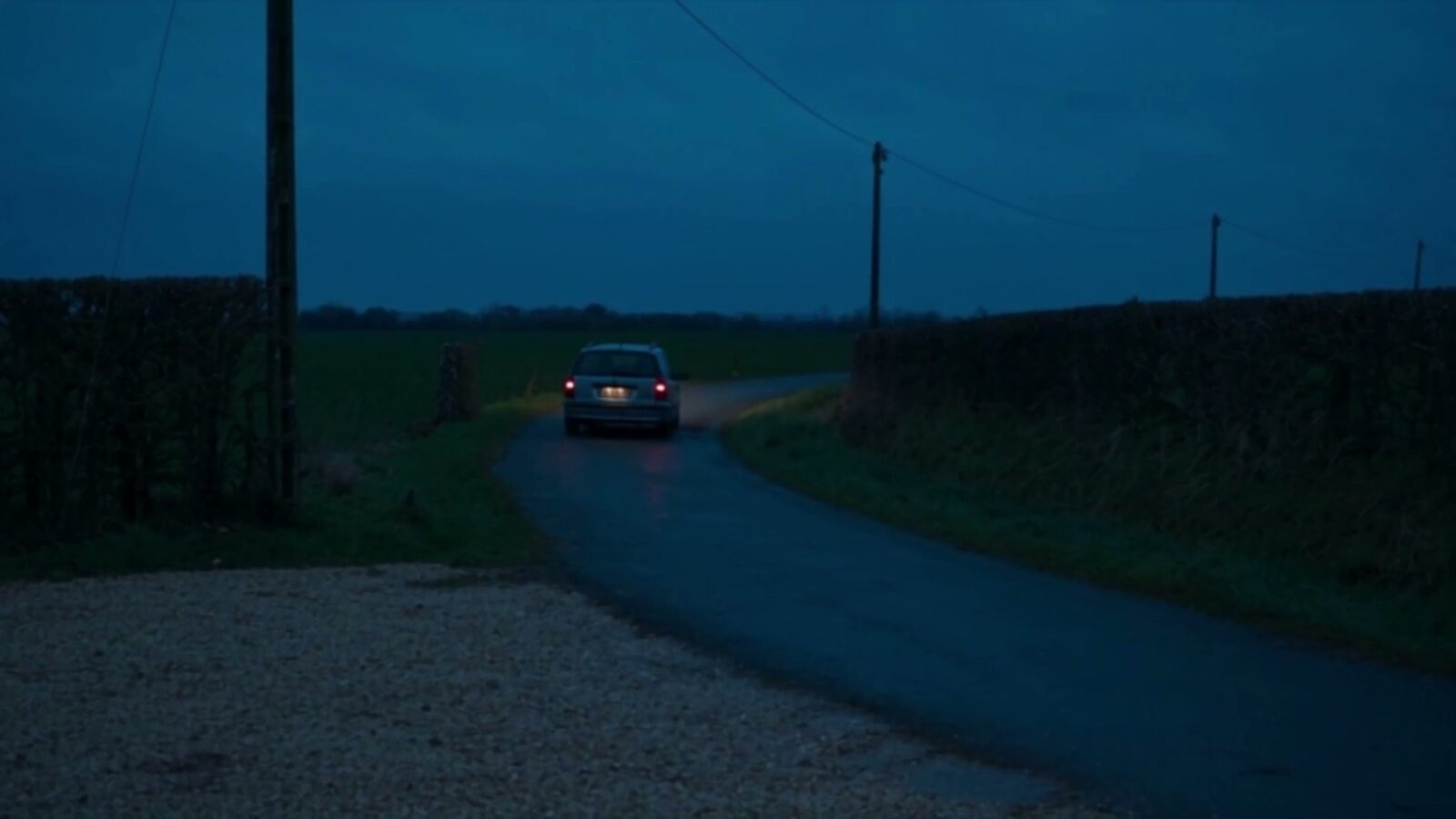 Une voiture seule sur une route de campagne à la tombée de la nuit