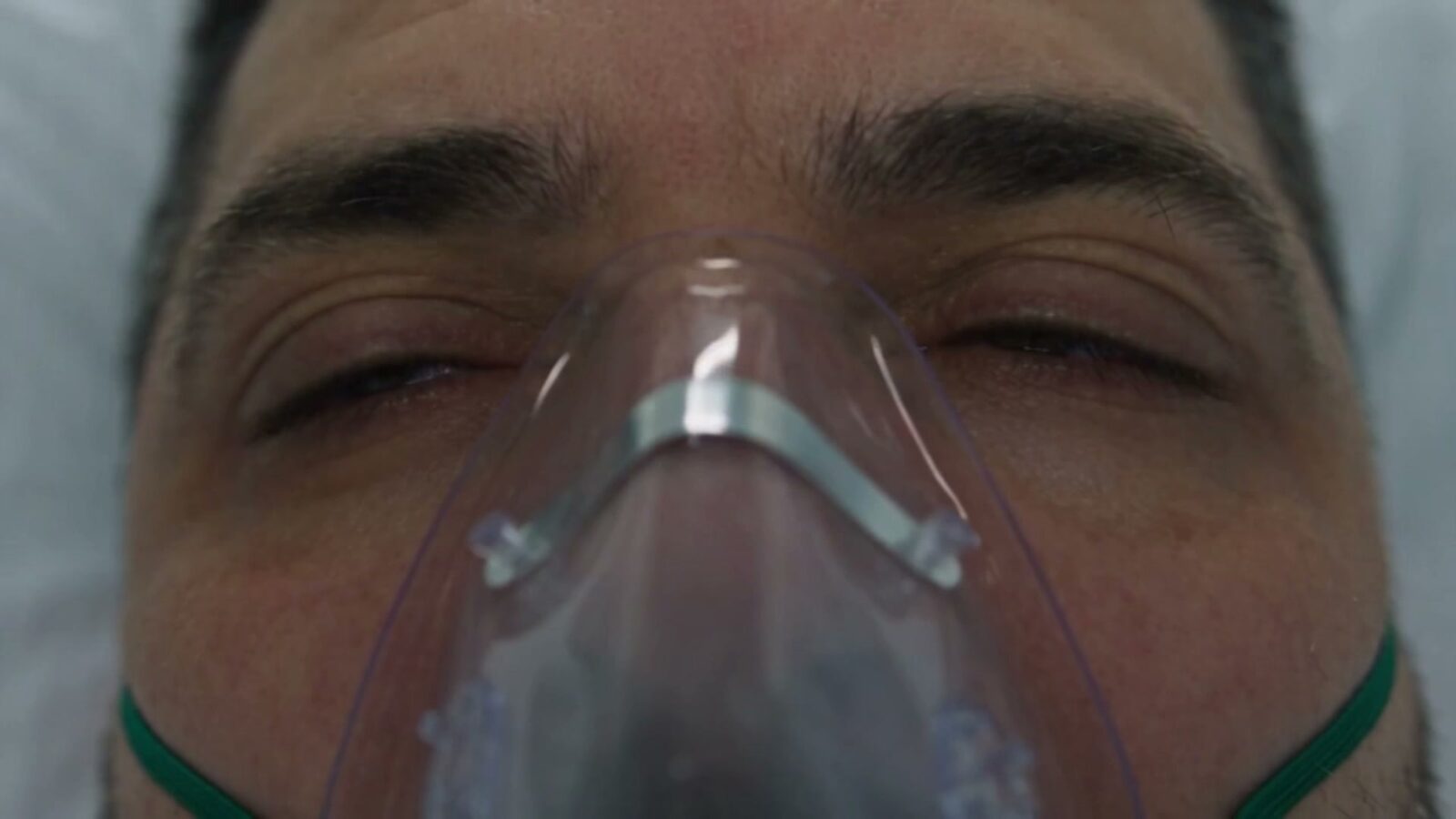 Le père inconscient sous un masque à oxygène