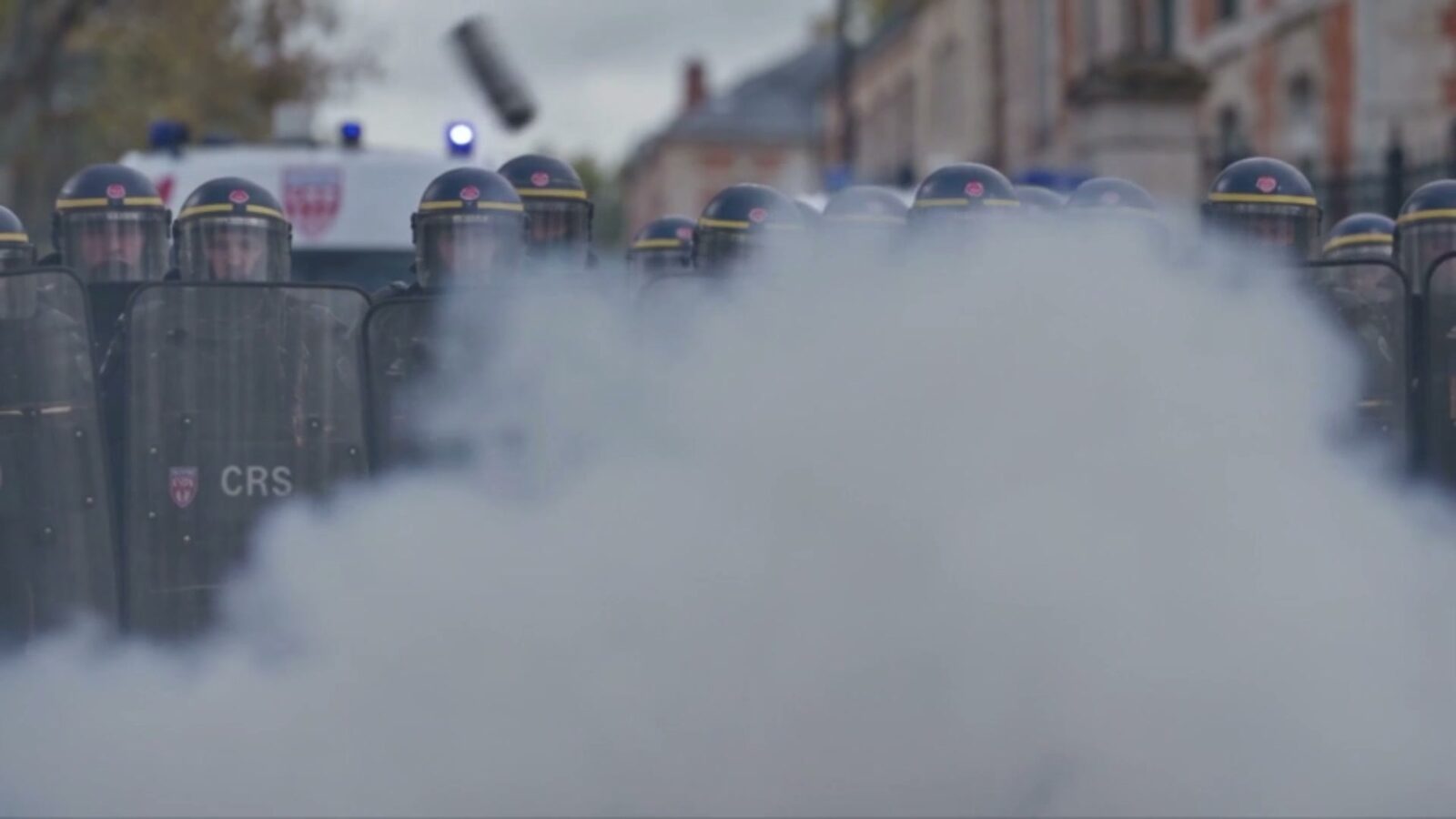 Un nuage de lacrymogène roule devant la ligne de boucliers des CRS