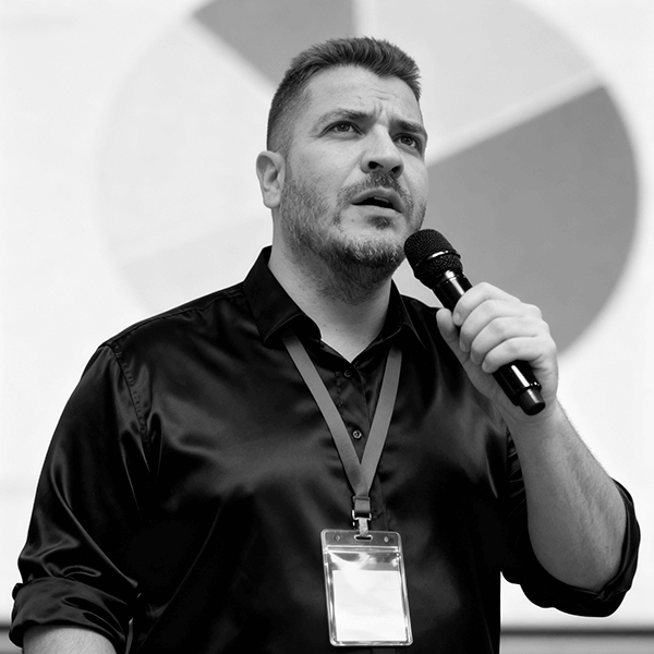 Stéphane Delgado en conférence, micro à la main, devant un public